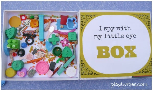 A box with assorted items in it and a lid that reads, "I spy with my little eye box".
