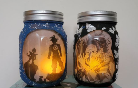 Photo of two jars featuring anime characters with a tealight candle inside of them.