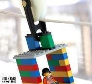 A photo of a lego character zipping down a zip line.