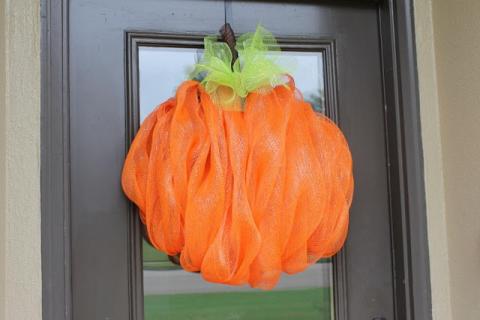 A pumpkin wreath hanging on a front door.