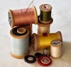 A pile of buttons and thread wound on bobbins