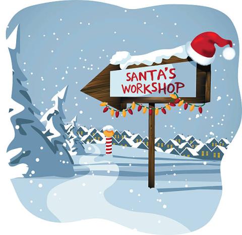 A wooden sign outside in the snow pointing to the left with the words "Santa's Workshop".