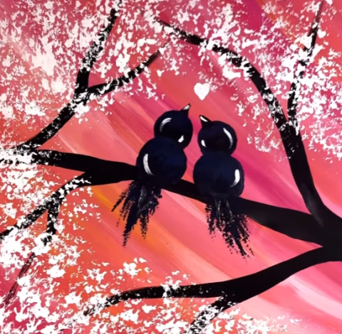 A picture of silhouetted lovebirds on a branch in front of a sunset background. 