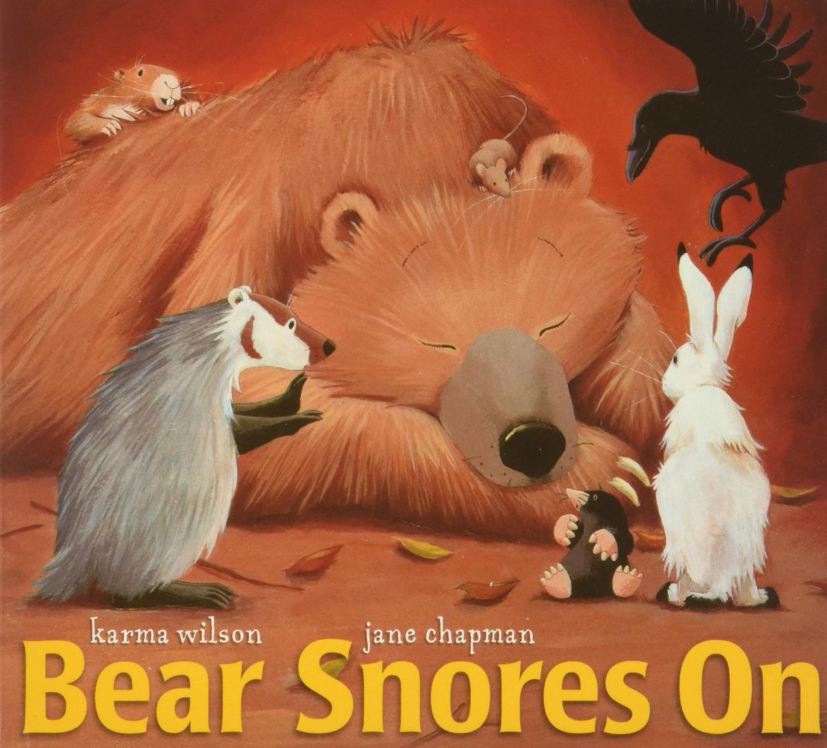 The cover of "Bear Snores On" by Karma Wilson, featuring a sleeping Bear surrounded by Badger, Mole, Rabbit, Wren, Mouse, and Gopher.