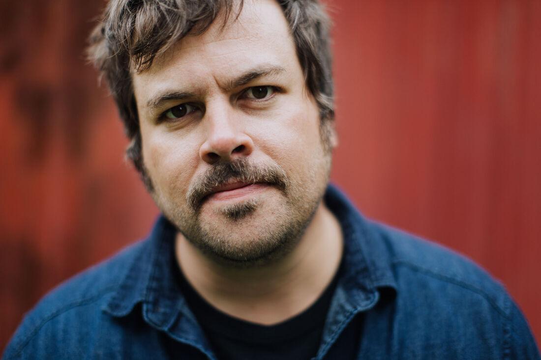 Close up of the musician Joel Sire's face. Joel is a white male with brown hair and mustache. 