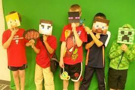 Children holding masks of Minecraft characters in front of their faces.