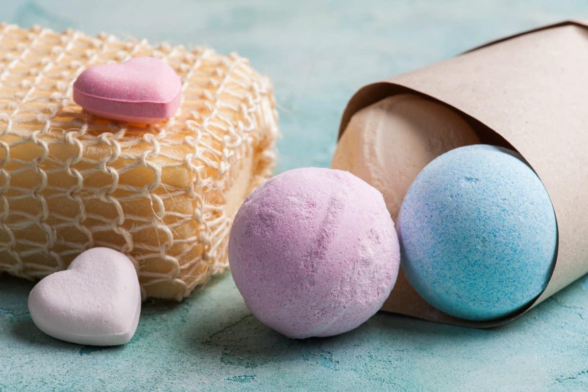 Image of colorful bath bombs with a loofah.