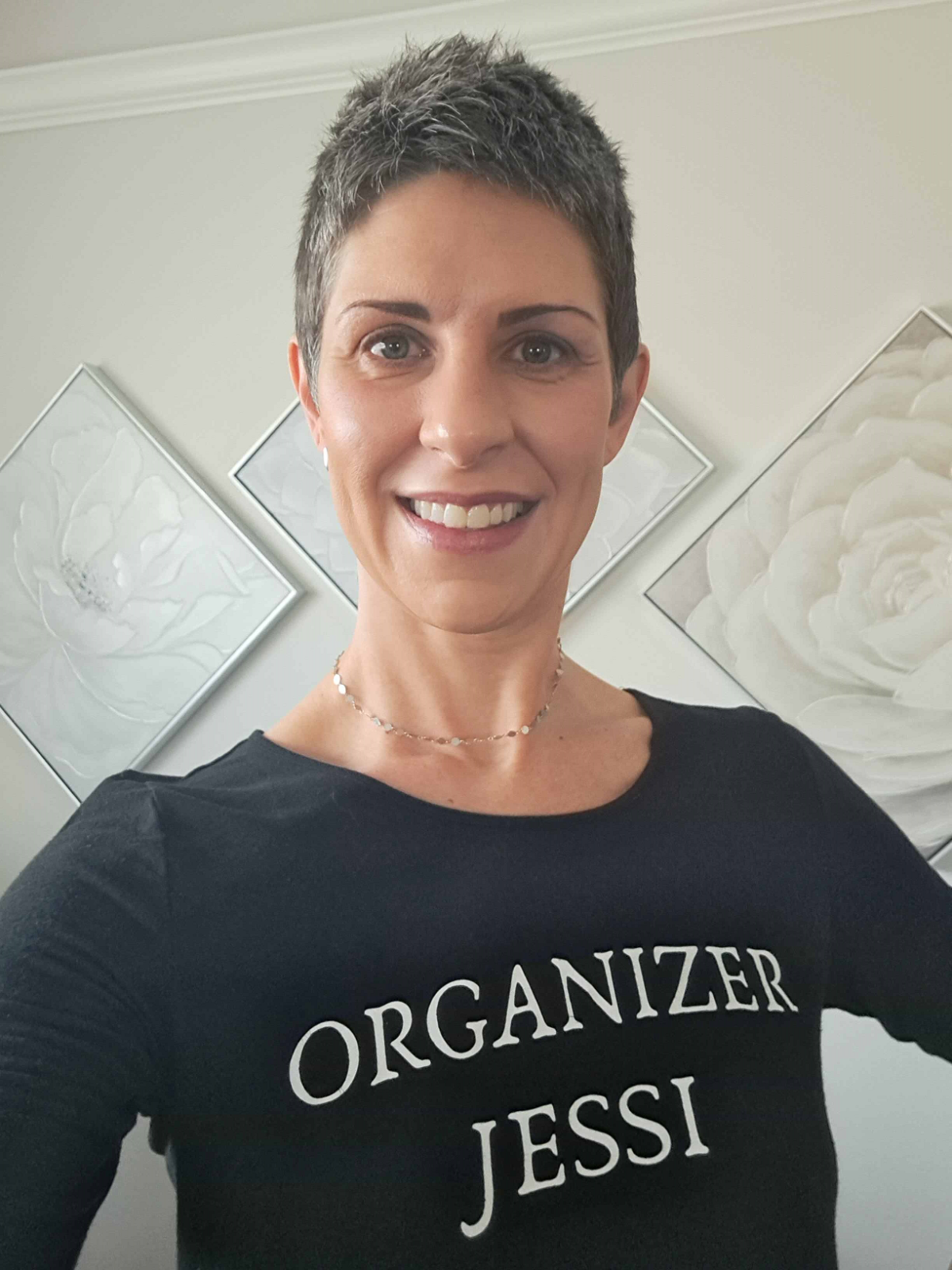 A medium close-up shot of Jessi Bushman wearing a shirt with her business name "Organizer Jessi." 