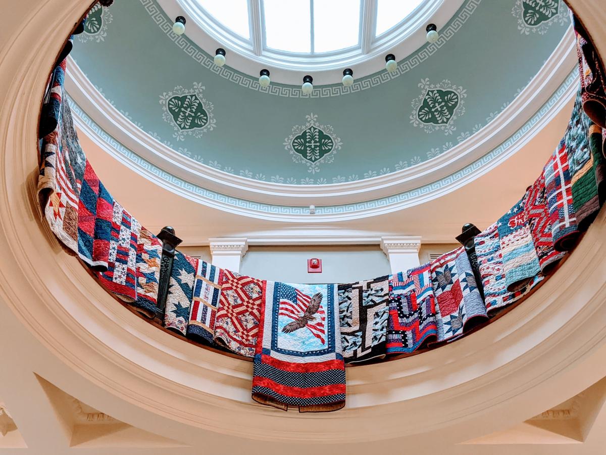 The Rotunda on the third floor of the library has colorful and patriotic quilts hanging neatly over the railing in a circle.