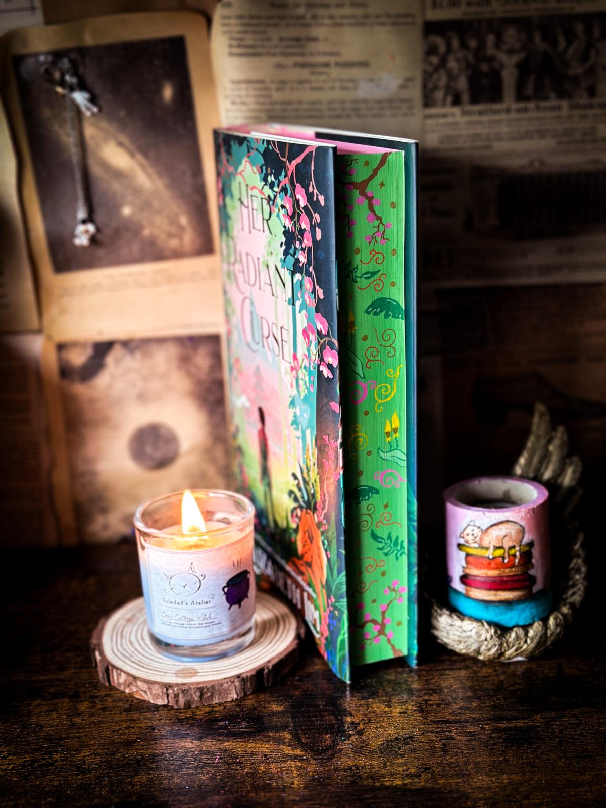 A photograph of a book's painted edges featuring simple spirals, leaves, and branches. 