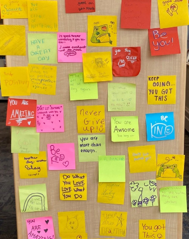 Bookshelf with encouraging sticky notes.